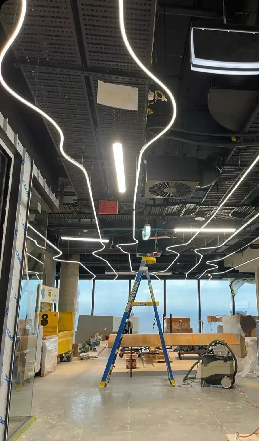 Curved LED feature lighting being installed during a Melbourne commercial fit-out by Accorto Electrical