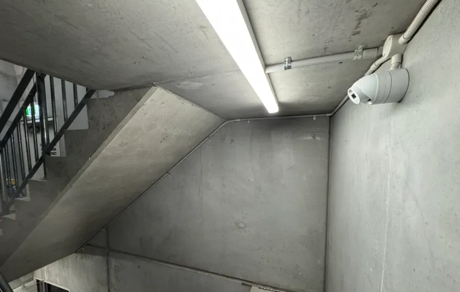 CCTV camera and batten lighting in a concrete car park stairwell installed by Accorto Electrical