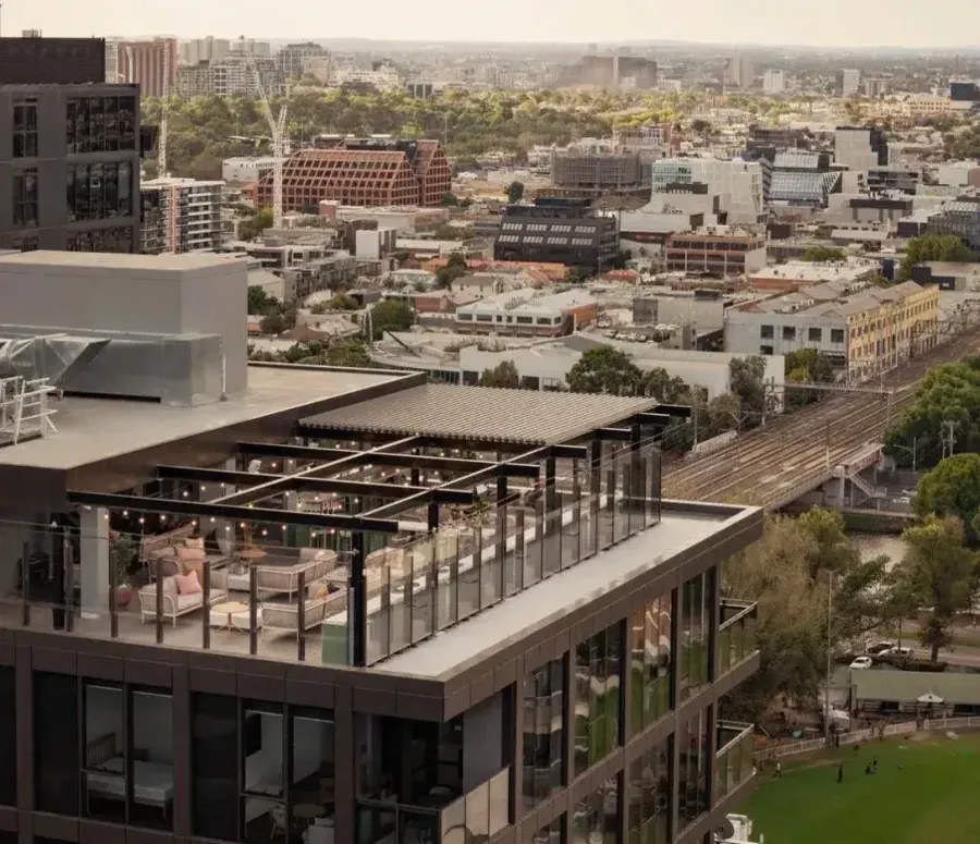 Rooftop bar terrace on a Melbourne high-rise with lighting by Accorto Electrical and city skyline beyond